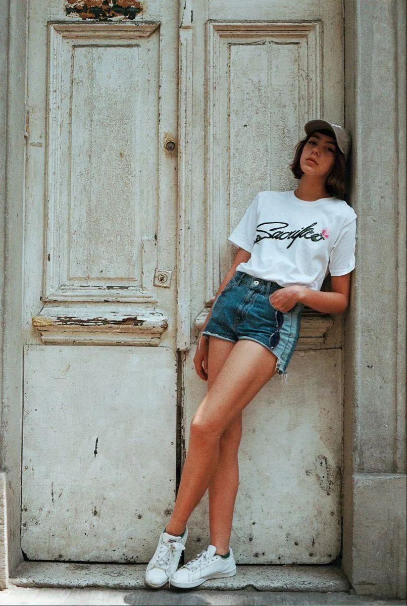 Relaxed Woman Leaning on a Rustic Door in Casual Clothes