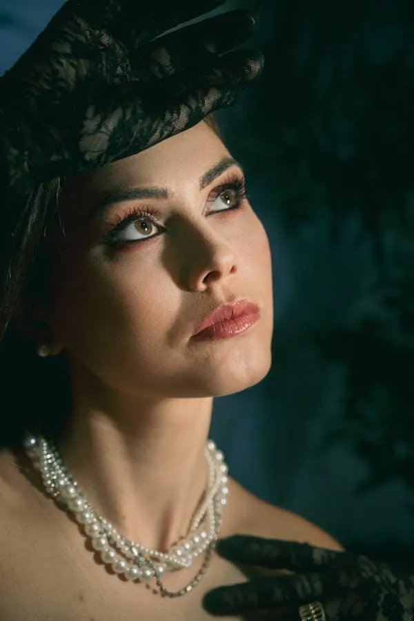 Retro Styled Woman Wearing a Pearl Necklace and a Hat Image