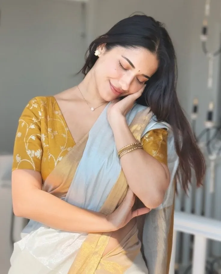 Ruhani Sharma in white saree standing with eyes closed pose