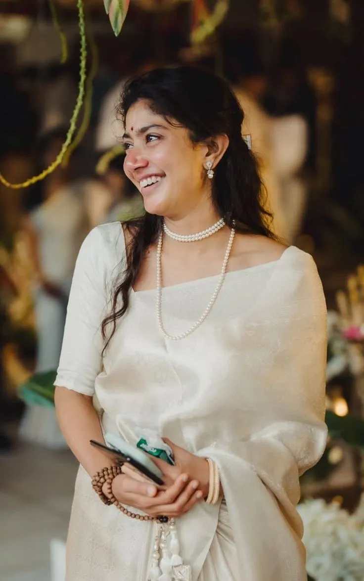 Sai Pallavi in a Nerial saree looking sideways with a smile