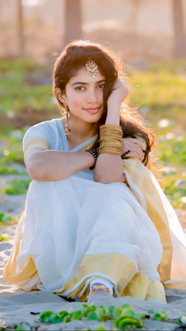 Sai Pallavi sitting on the beach with her hand on her cheek