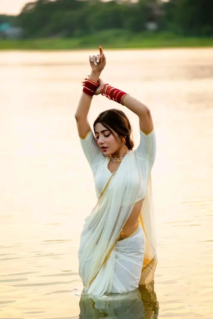 Samonty Shoumi standing in the water with hand raised pose