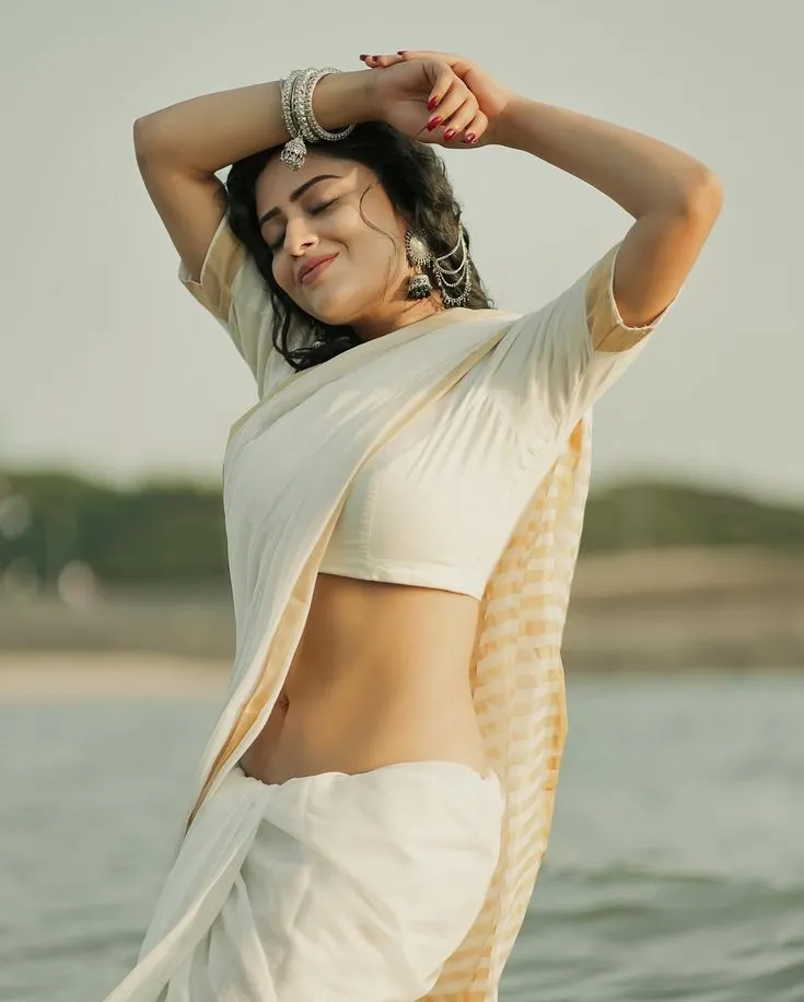 Sanya Thakur in a Nariyal Saree standing near the water
