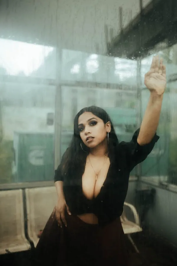 Sensual Model Posing with Hand Raised in a Misty Window