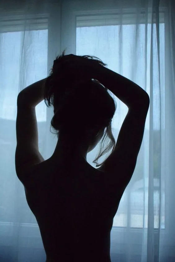 Silhouette of a Woman Behind Sheer Blue Curtains Wallpaper