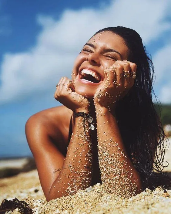 Smiling Woman Enjoying the Beach with Wet Sandy Hands Image