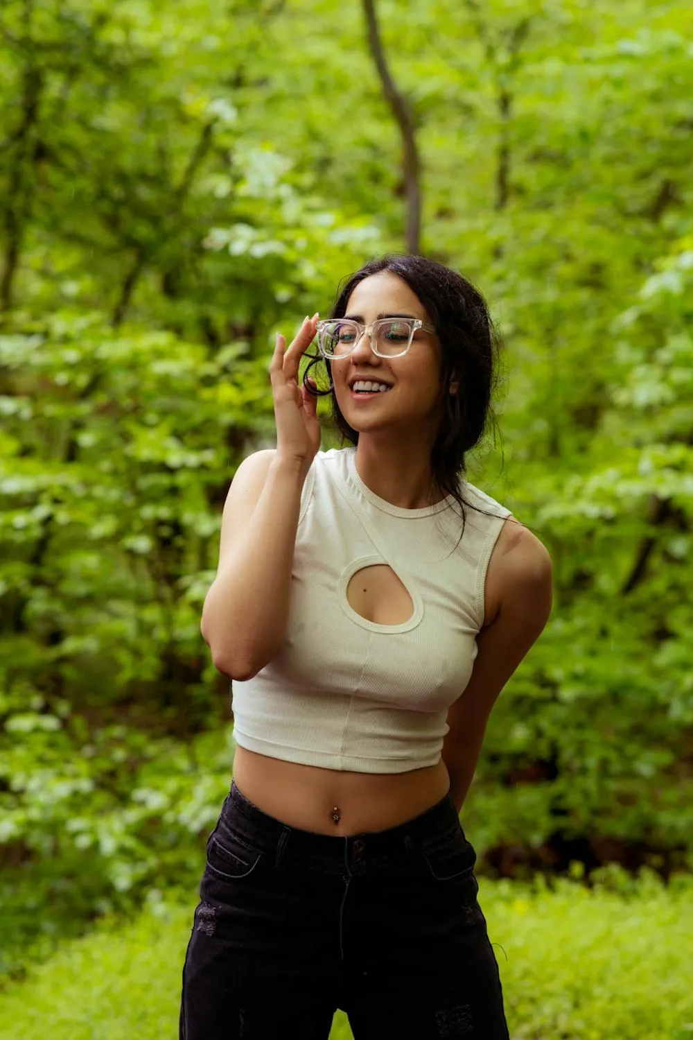 Smiling Woman in a Green Top Standing in a Sunny Park Image