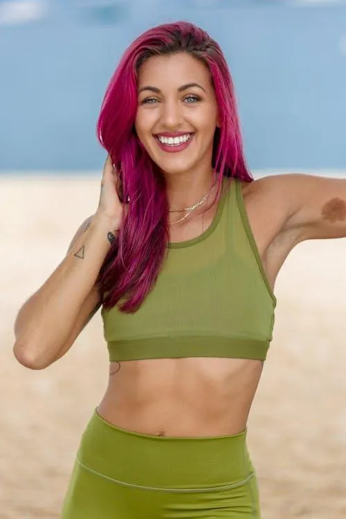 Smiling Woman in Green Workout Outfit Standing on the Beach