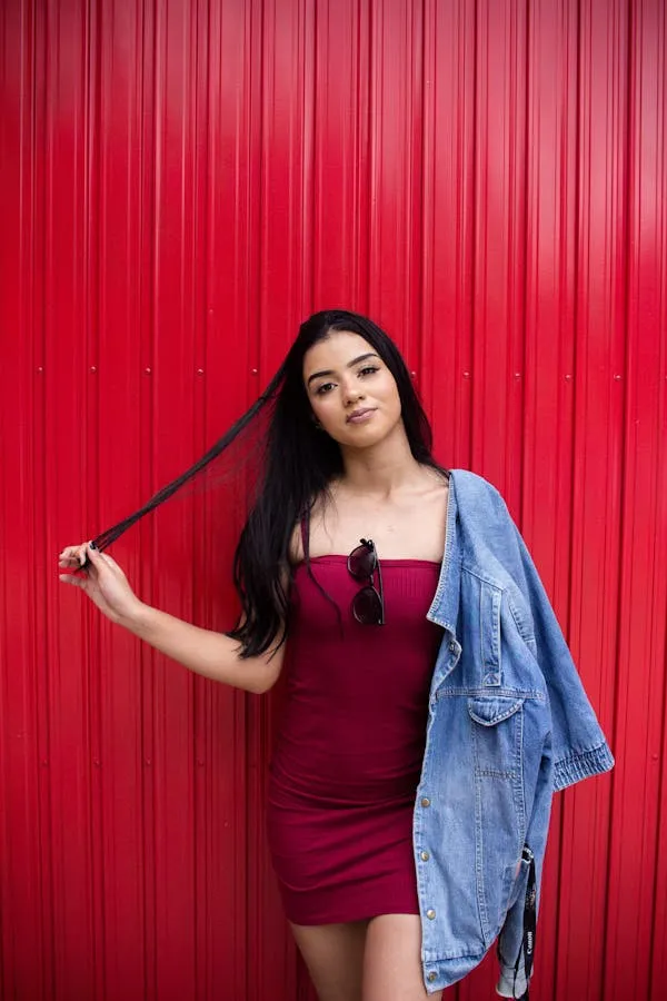 Smiling Woman with Long Black Hair Near a Red Background