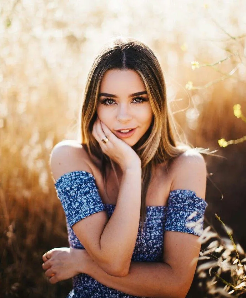 Smiling Woman Posing in a Field with Sunlit Golden Hair