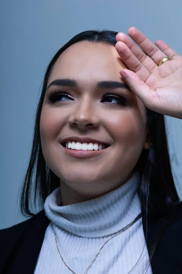 Smiling Woman Shielding Her Eyes From Bright Studio Light