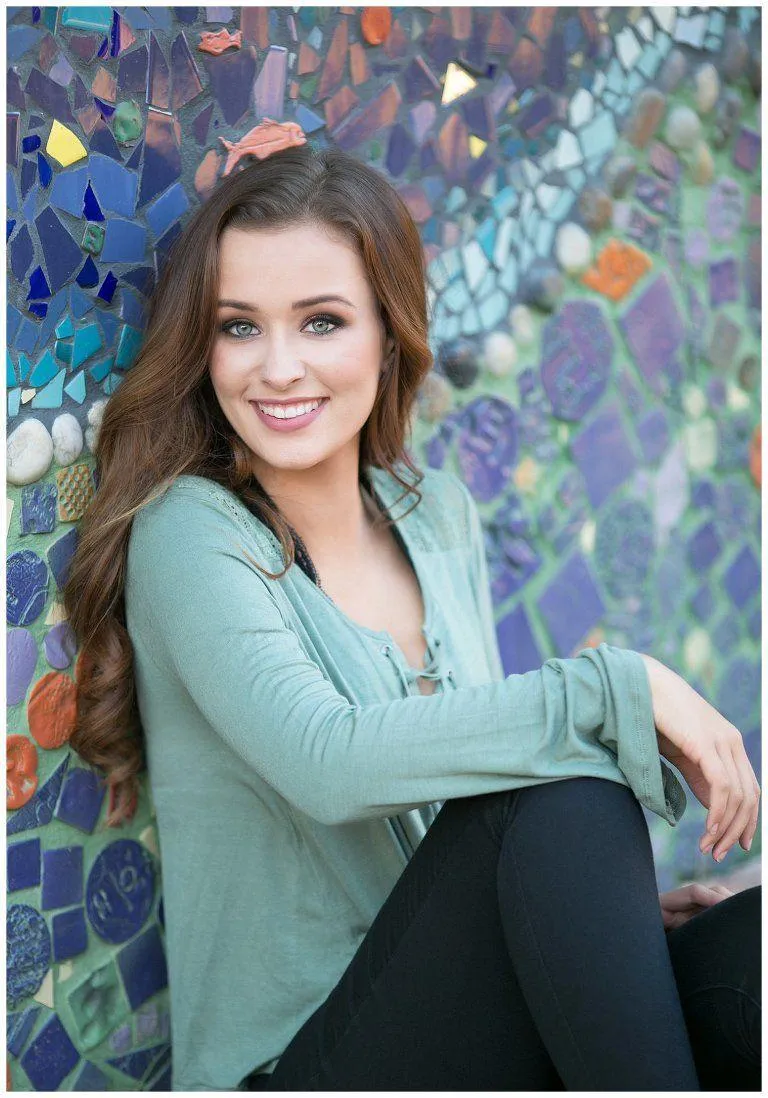 Smiling Woman Sitting in Front of Colorful Wall Hd Wallpaper