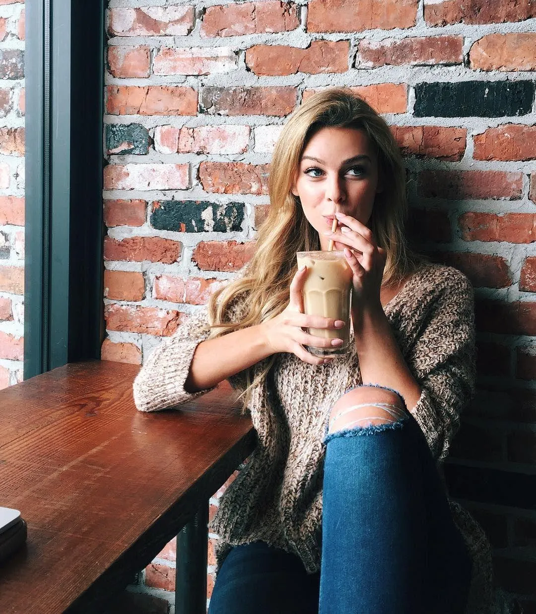 Smiling Woman in a Striped Dress Near Colorful Lights Image