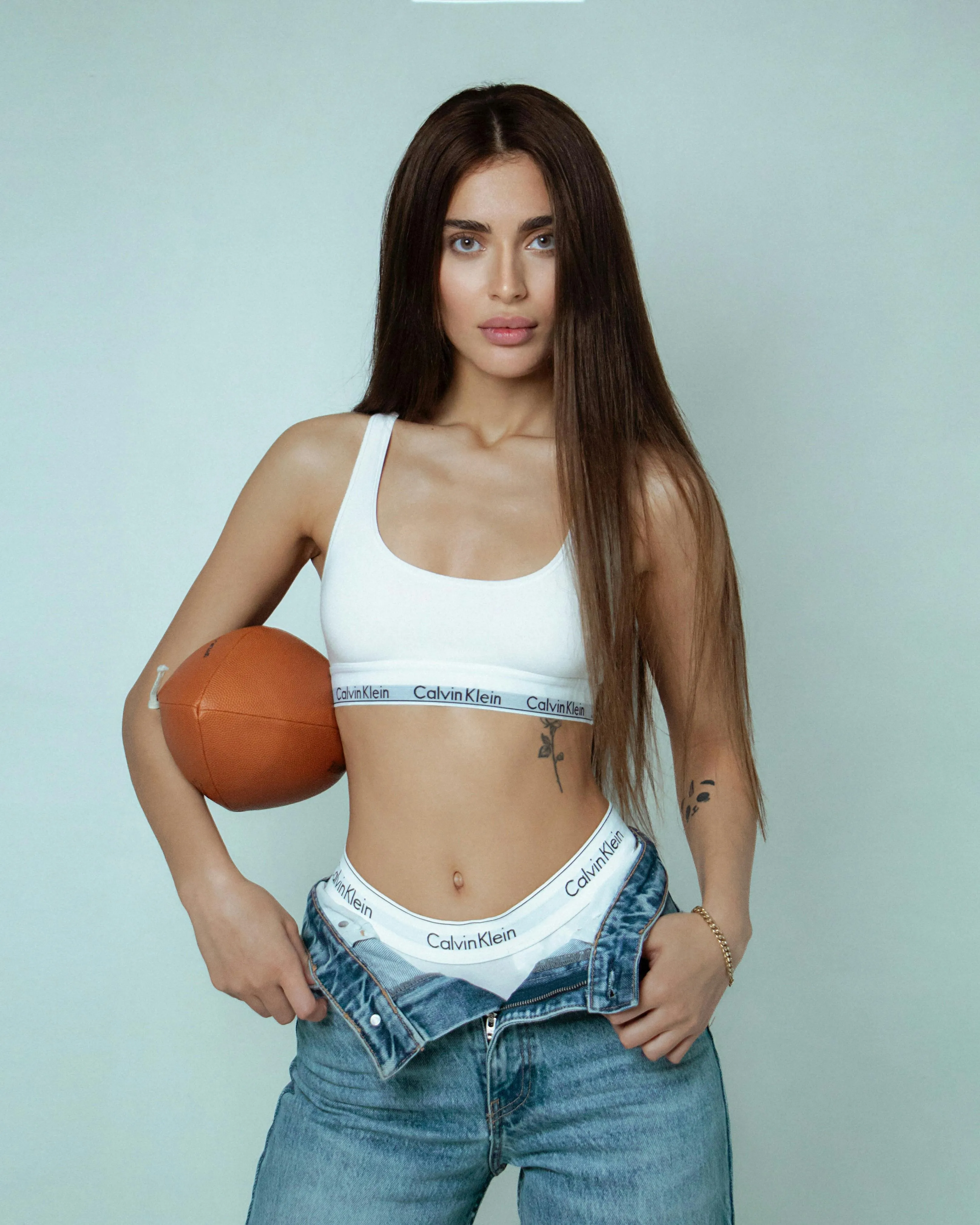 Sporty Woman in Crop Top Holding a Basketball in Casual Pose