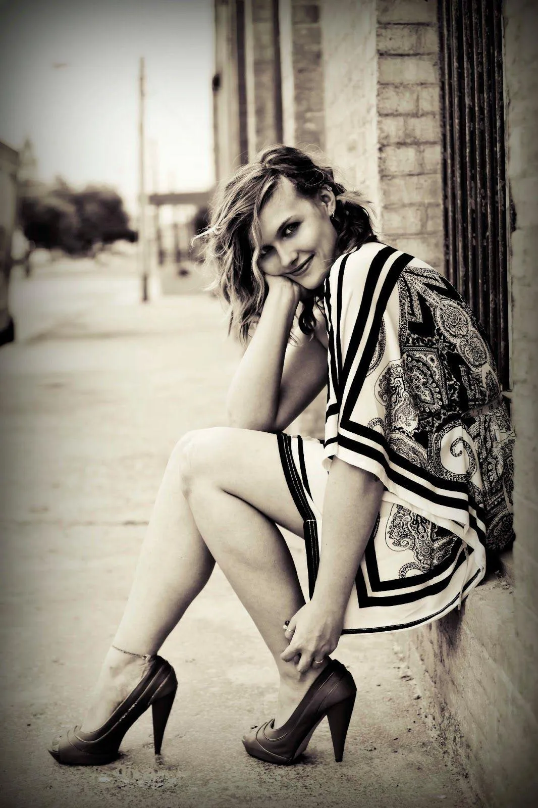 Stylish Girl in Heels Sitting with Legs Crossed Posing Image