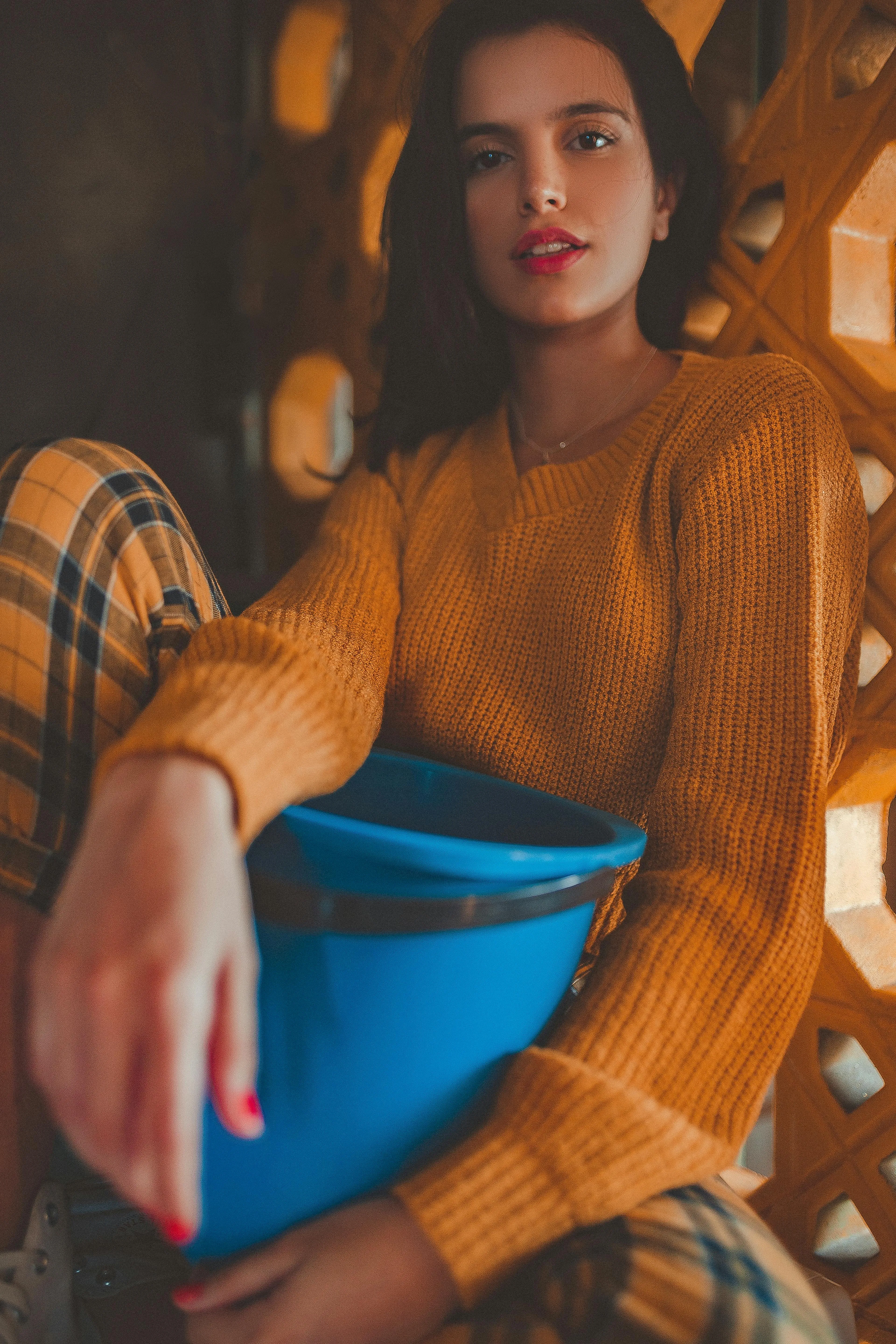 Stylish Woman in an Orange Sweater Holdinga a Blue Purse