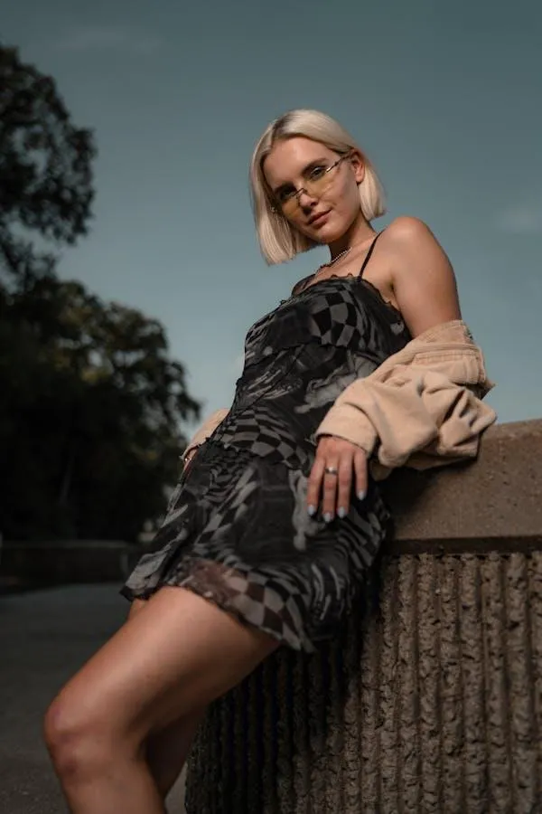 Stylish Woman in a Black Dress Posing Confidently Outdoors