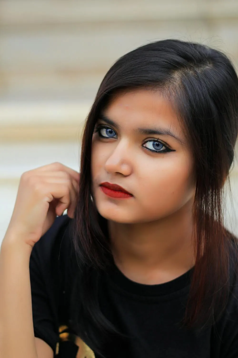 Stylish Woman in a Black Outfit with Intense Eye Makeup Pose