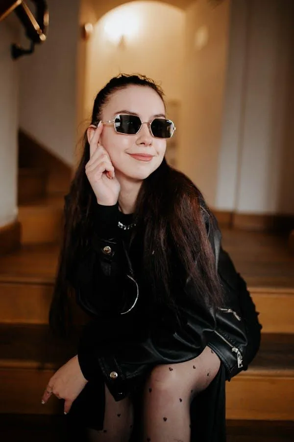 Stylish Woman in a Black Outfit Wearing Sunglasses Indoors