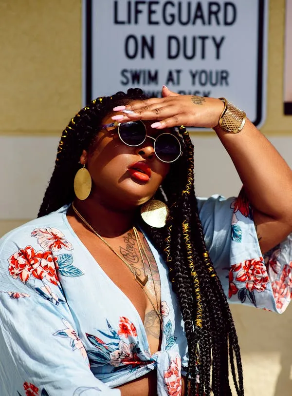 Stylish Woman with Braids Shielding Her Eyes From the Sun