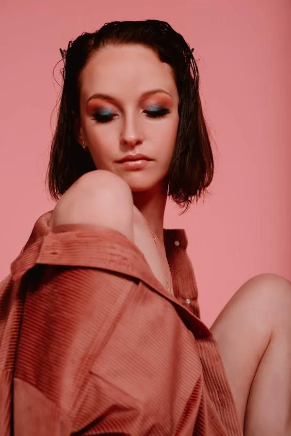 Stylish Woman in a Brown Jacket with a Pink Background Image