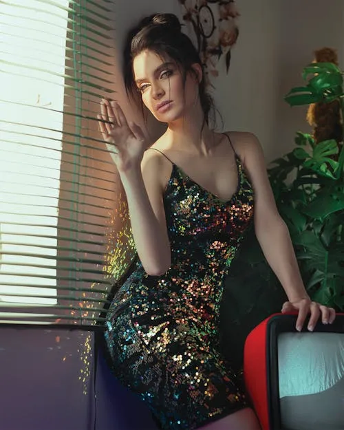 Stylish Woman in Elegant Dress Sitting Beside Window Blinds