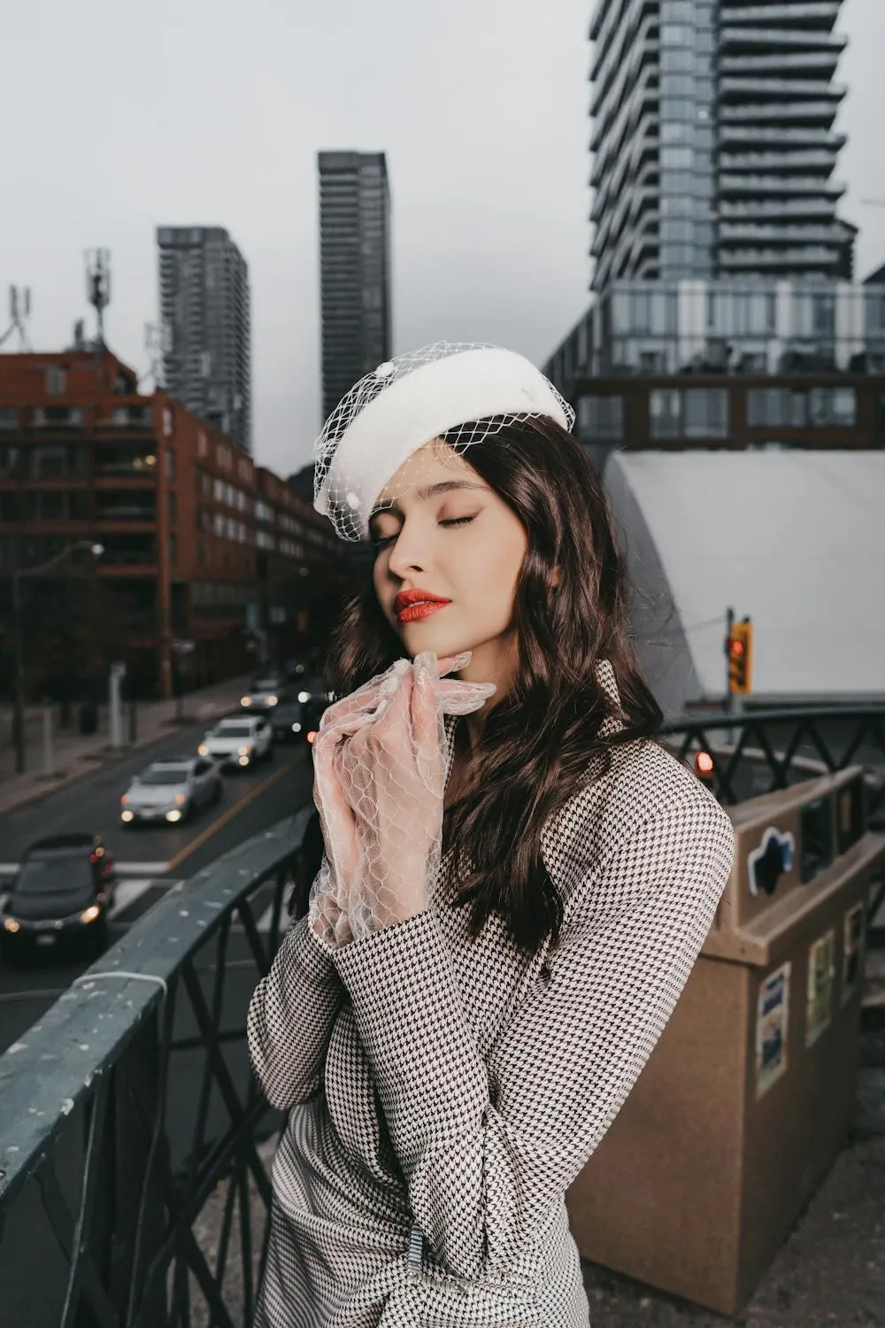 Stylish Woman in a Hat Posing on a City Bridge with Elegance