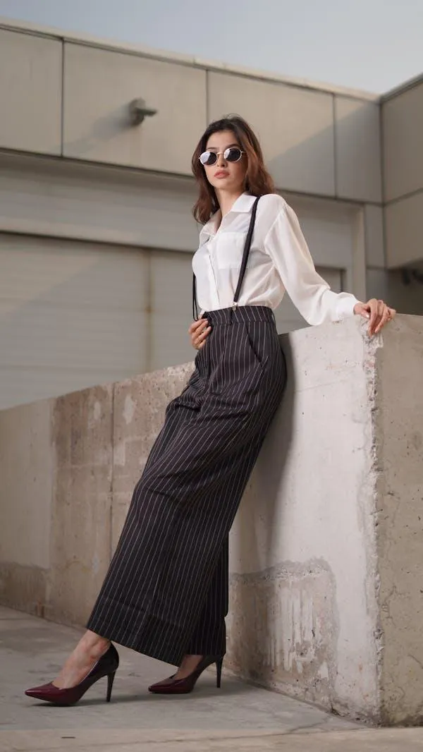 Stylish Woman Leaning on a Ledge in a White Shirt and Slacks