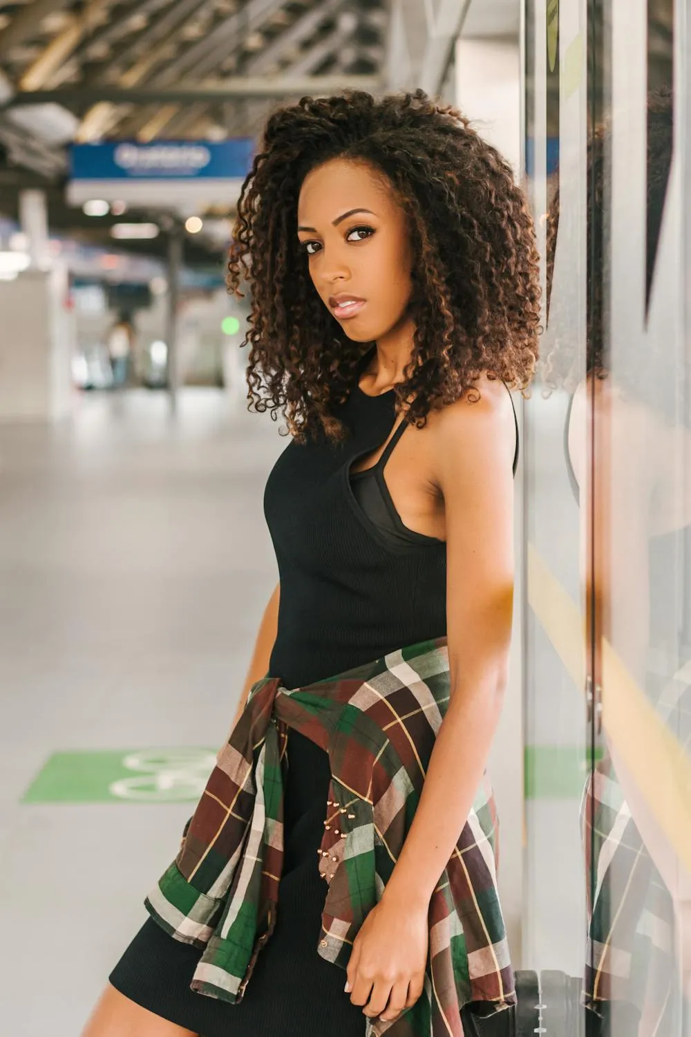 Stylish Woman in a Plaid Skirt At the Metro Platform Image