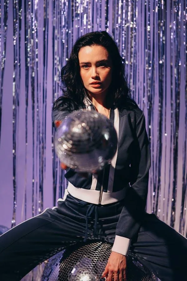 Stylish Woman Posing with a Silver Balloon in a Studio Image