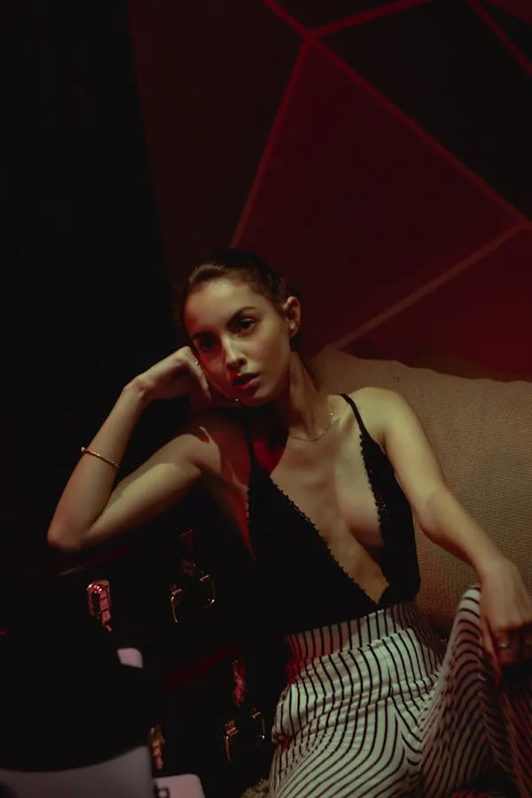 Stylish Woman in Striped Pants Sitting on a Chair Wallpaper