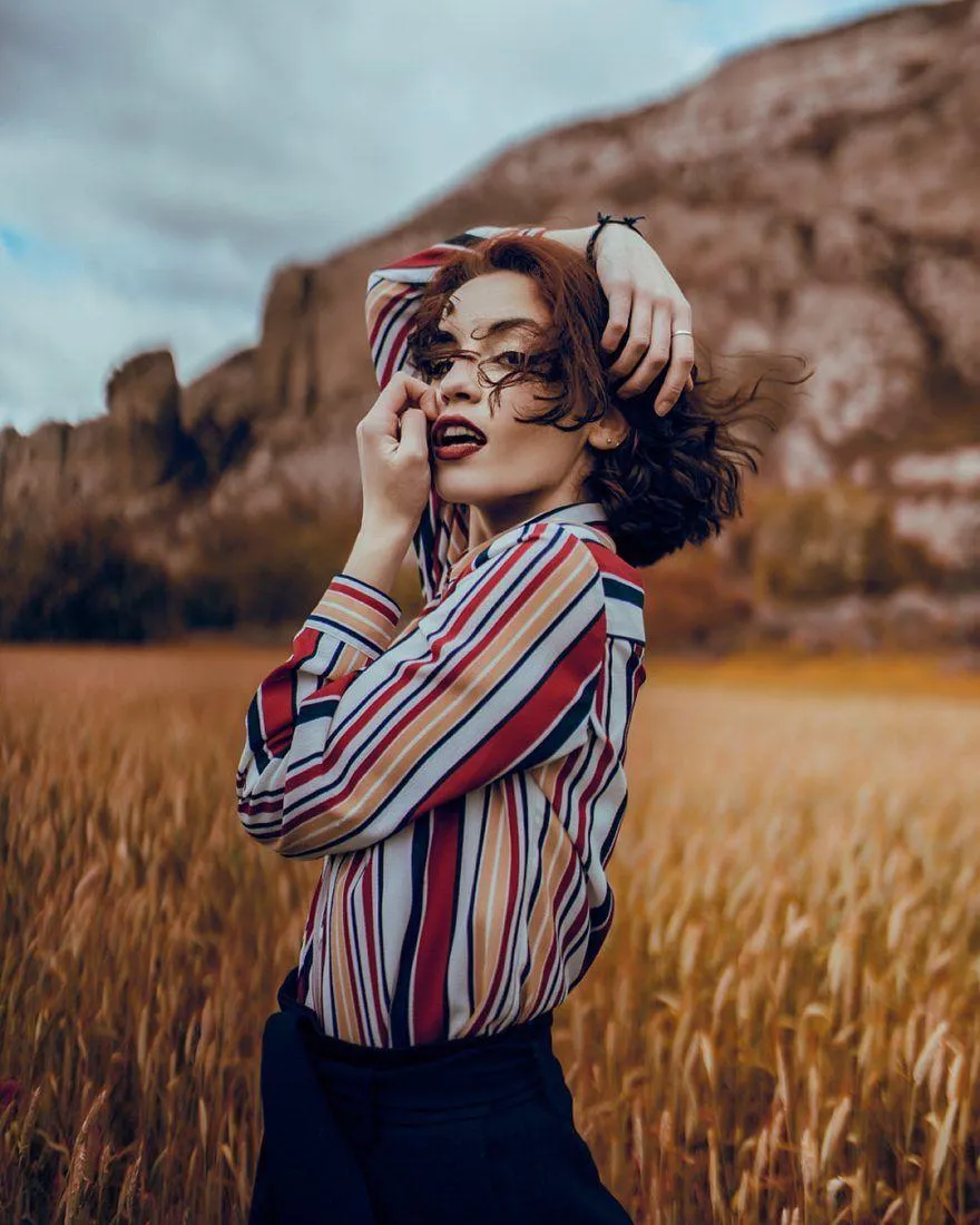 Stylish Woman in Striped Shirt Posing in an Open Wheat Field