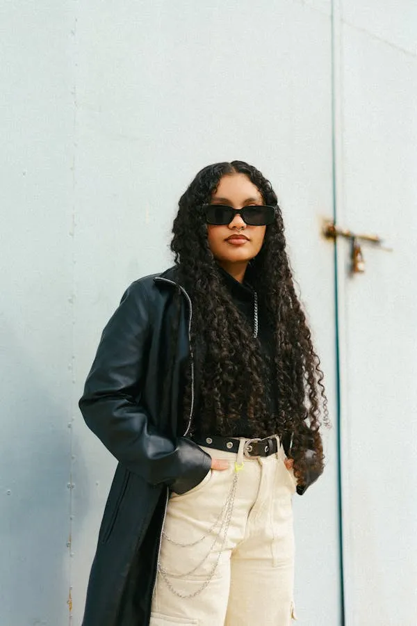 Stylish Woman in Sunglasses and a Leather Jacket Standing