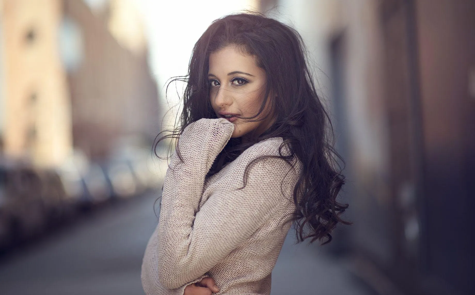 Stylish Woman in Sweater Looking Over Her Shoulder Outdoors