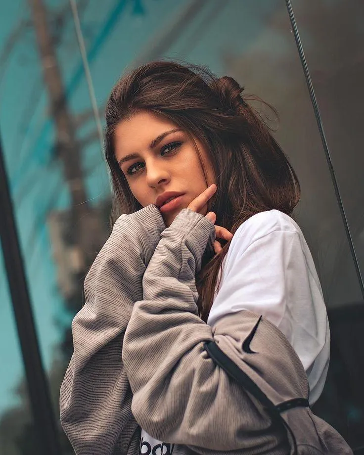 Stylish Woman Walking Near a Vintage Car in Sunny Street