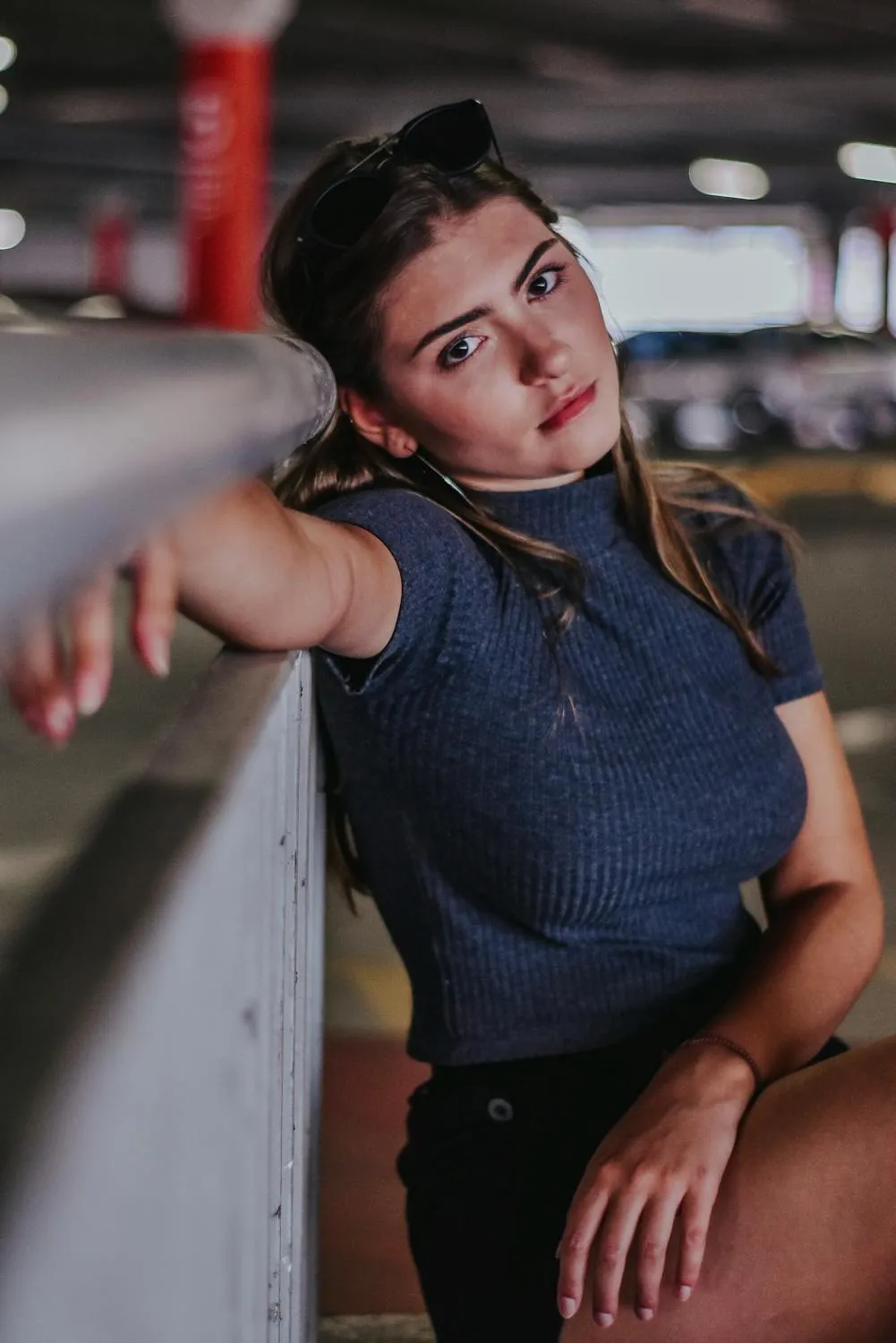 Stylish Young Woman Leaning Casually on a Railing Wallpaper
