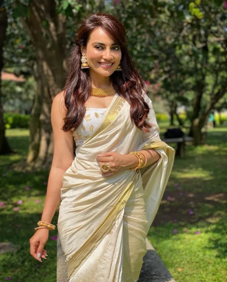 Surbhi Jyoti in an Onam saree standing on the grassy field