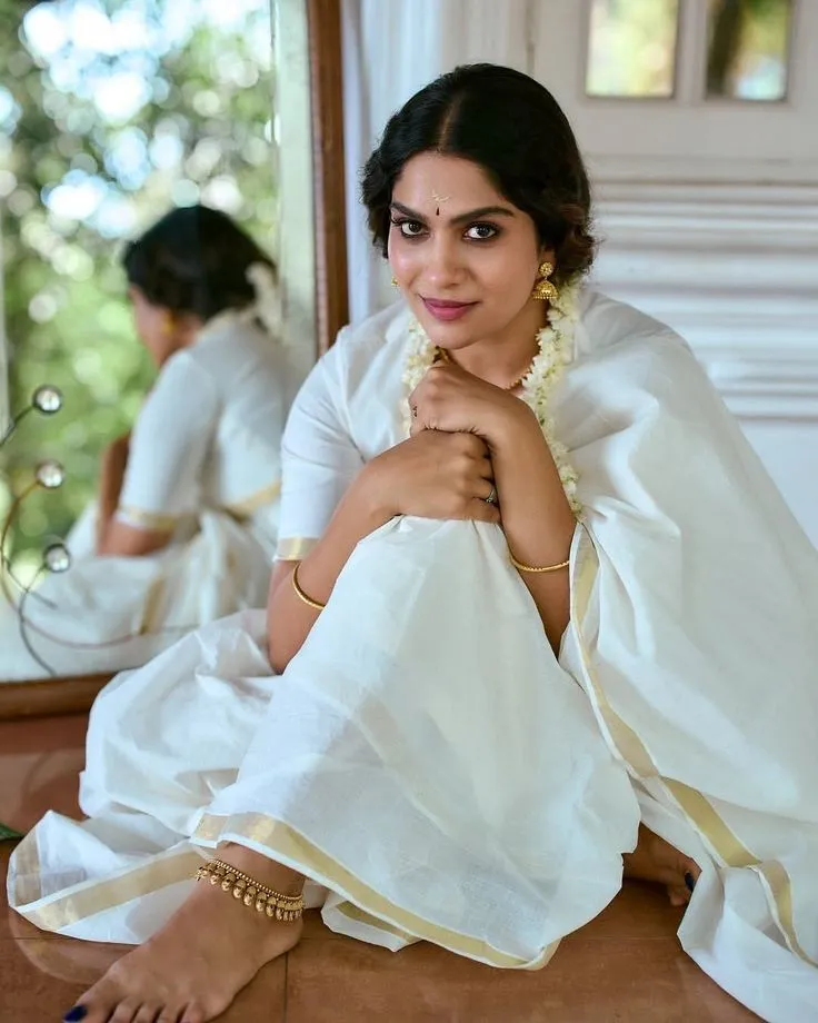 Swasika in an Onam saree sitting near a mirror HD wallpaper