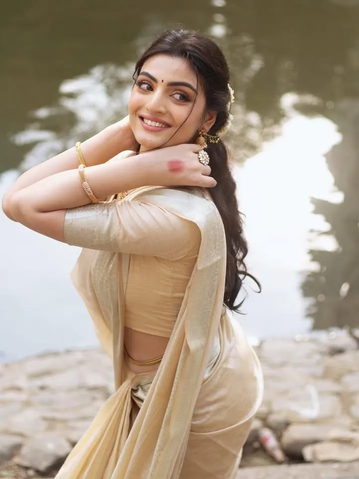 Swati Sharma in a golden saree standing the water wallpaper