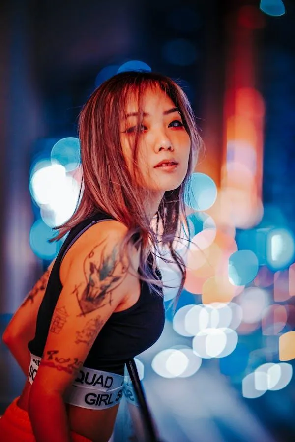Tattooed Woman Posing At Night with City Lights Behind Image