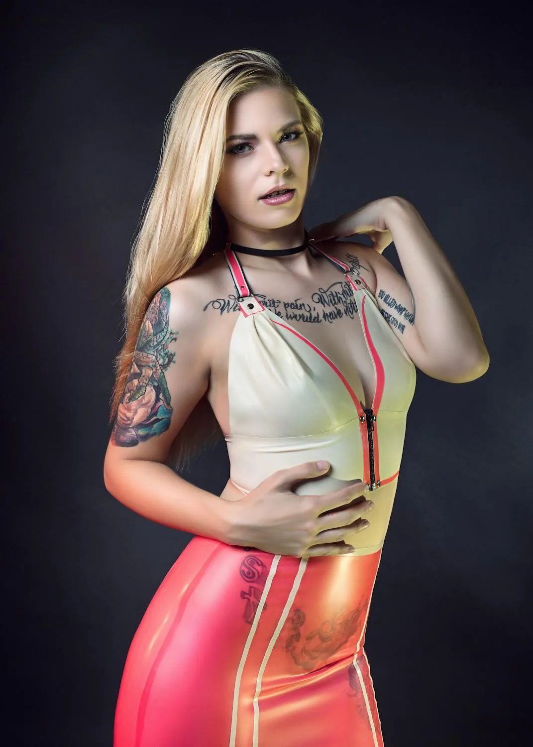 Tattooed Woman in Vibrant Dress Striking a Bold Fashion Pose