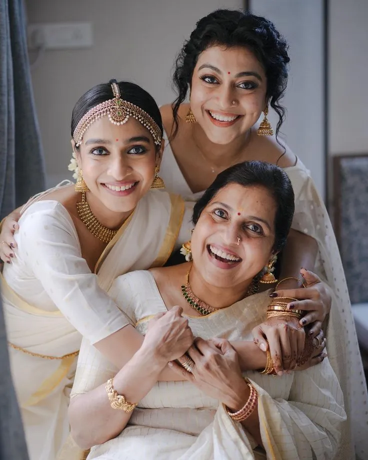Three women in a traditional Kerala saree with a smile image