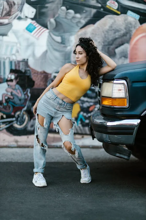Trendy Woman in an Orange Top Dancing Beside a Parked Truck