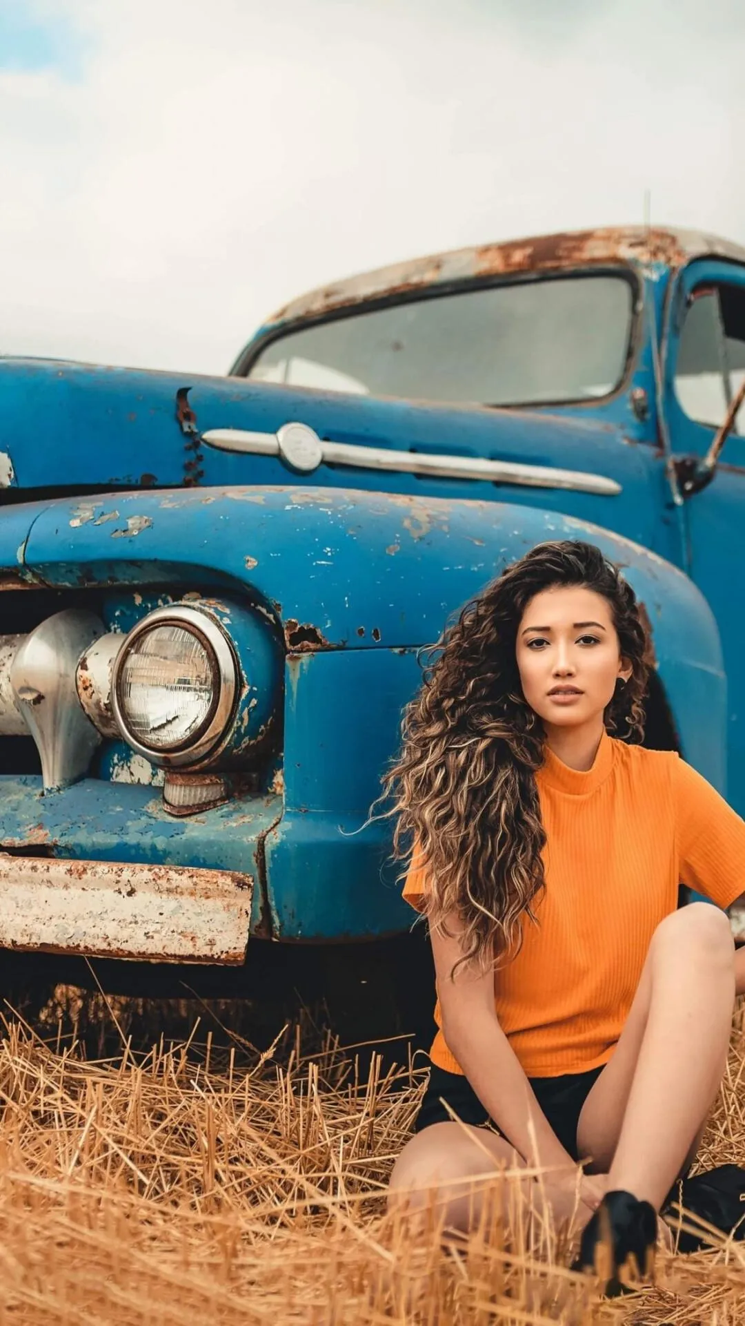 Two Girls Sitting on a Red Suv Roof Enjoying Mountain View