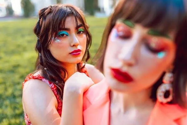 Two Women with Colorful Makeup Posing Closely Together Image