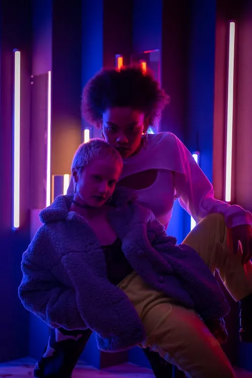 Two Women Posing Together in Neon Lighting Free Wallpaper