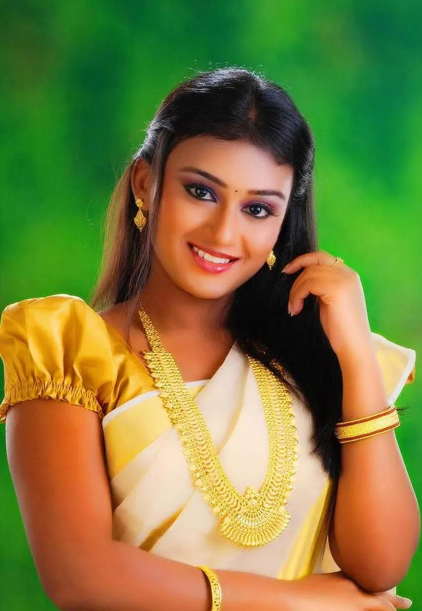 Varada in a traditional Kerala saree with a green background