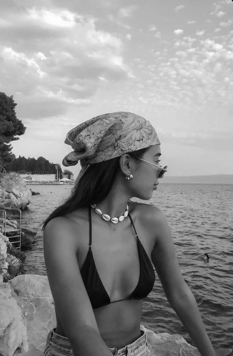 Vintage Style Woman Sitting Near Water in a Headscarf Image