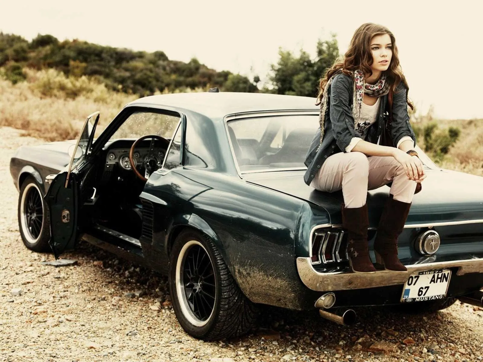 Vintage Styled Woman Sitting on the Hood of a Classic Car