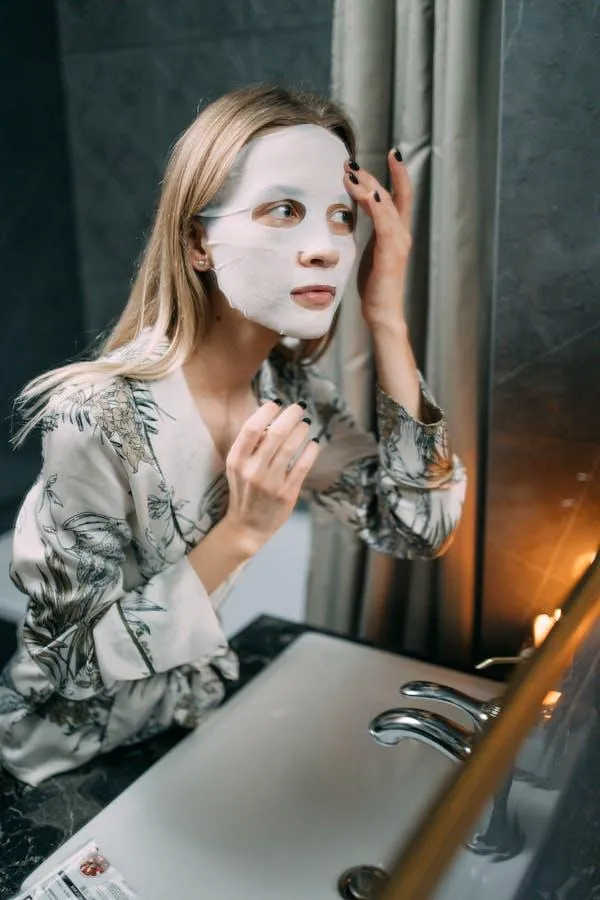 Woman Applying a Sheet Mask During Skincare Routine At Home